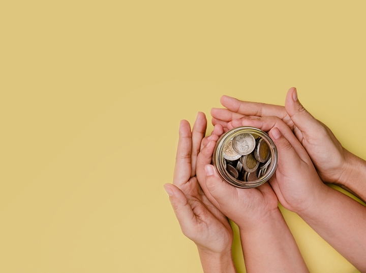 Paper and coin currency in the palm of a hand